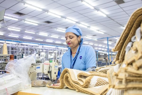 Textile production specialist sewing a garment